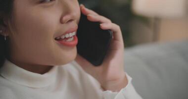 asiático mujer hablando con amigos o familia en un teléfono inteligente foto