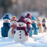 a group of snowmen standing in the snow together with scarf on their heads and neck photo