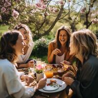 Friends sharing laughter and meals under the canopy of blossoming trees in a spring garden photo