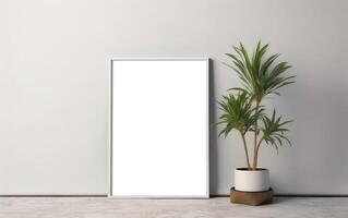 White frame mockup on light grey wall with green plant in vase, blank vertical frame with copy space. Contemporary interior mockup. photo