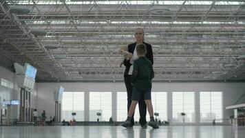 een vrouw met een baby dochter en een zoon in een luchthaven hal video