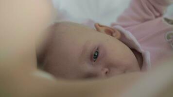 une lent mouvement de une somnolent bébé fille étant allaité video