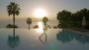 A steadicam shot of a glossy open pool surface on a sunset video