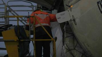 An airport worker on the elevator watching the load delivery video