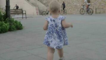 Back view of baby girl walking in the street video