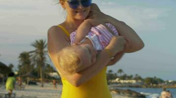 mamma framställning bebis dotter skratt familj avkopplande på de strand video