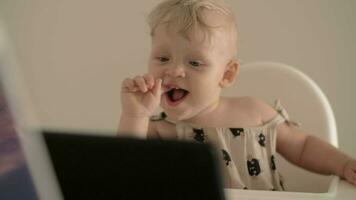 One year child watching cartoons sitting in highchair video