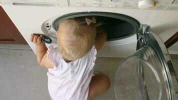 peu enfant explorant le la lessive machine video