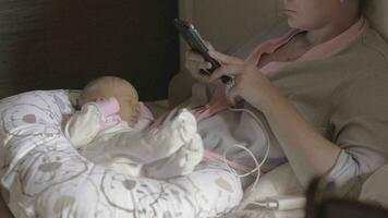 Anonymous woman with baby using smartphone video