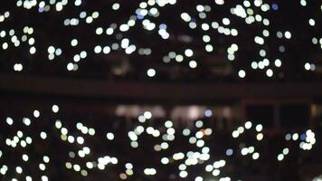 Audience inside an arena with their cellphone screens on video