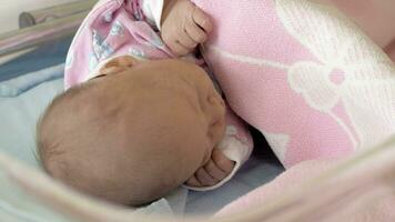A closeup of a newborn baby sleeping under the pink blanket video