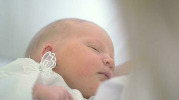 Newborn baby girl asleep in her mothers arms video