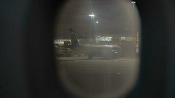 View to night Sheremetyevo Airport from illuminator of arrived plane, Moscow video