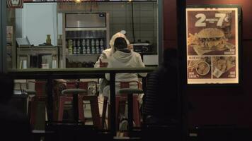 Grandma and grandchild having fast food dinner, view through cafe window video