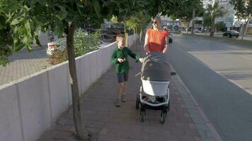 femme avec les enfants ayant une marcher dans le ville video