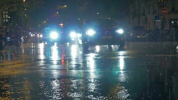 carros com brilhante faróis viga dirigindo dentro cidade às chuvoso noite Paris, França video