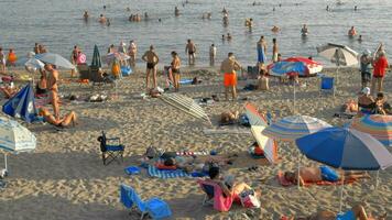 Vacationers relaxing at beach and bathing in sea, Greece video