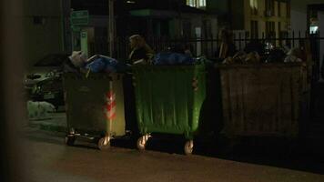 cidade rua com cheio desperdício containers, noite Visão video