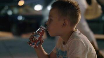 Boy drinking yoghurt outdoor at night video