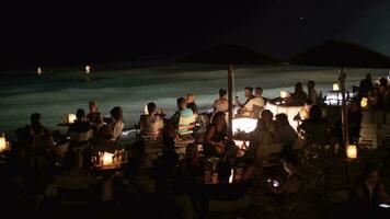 personas relajante en al aire libre mar apuntalar café a noche video