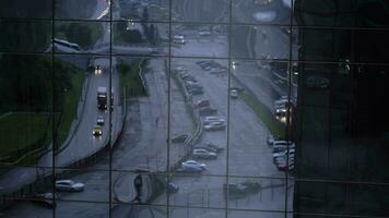 reflejo de calle con coche tráfico en vidrioso edificio fachada video