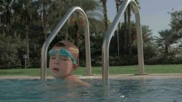 Child having fun in swimming pool and splashing water video