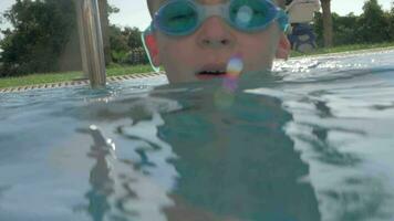 Child diving in outdoor swimming pool on resort video