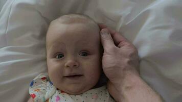 un seis meses antiguo bebé niña sonriente a del padre toque video