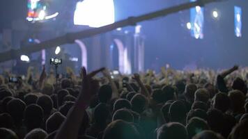 concert public avec mains en haut et brillant étape lumières video