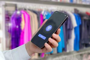 Quick and convenient payment using a mobile phone at a clothing store. Modern phone app interface with NFC payment photo