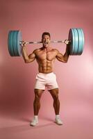 A committed man lifting a heavy barbell isolated on a dynamic gradient background photo