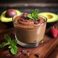 a chocolate dessert with chunks and mint leaves on wooden table photo