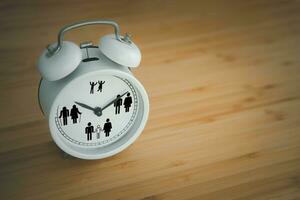 Clock on table with circle of life kid adult family and old icons. Lifetime and people growth concept photo