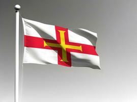 Guernsey national flag waving on gray background photo