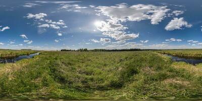 spherical 360 hdri panorama among green grass farming field near melioration reclamation canal in equirectangular seamless projection, as sky dome replacement, game development as skybox or VR content photo