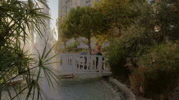 Mother with children walking in hotel garden with fountains video