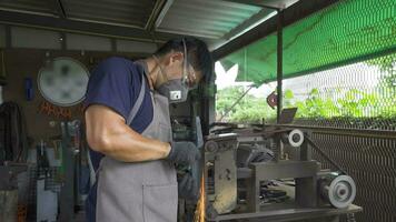 A blacksmith polishes the knife on the sandpaper, 4k footage video