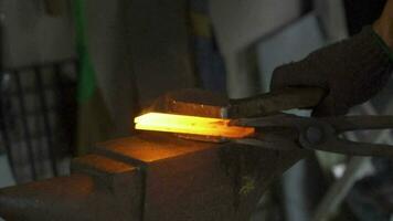 Blacksmith hitting a hot metal rod,  slow motion shot video