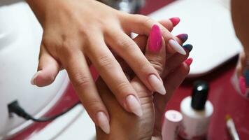 From above of crop unrecognizable manicurist doing nail art for female client in beauty salon video