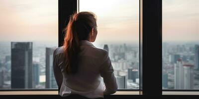 un de mujer de negocios mirada sobre el majestuoso rascacielos desde su oficina, irreconocible rostro. generativo ai foto
