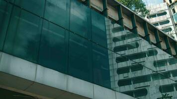 an Asian man standing in front of the window while contemplating the stress on himself in a building video