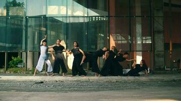 a group of Asian men posing with their flexible bodies while wearing black and white clothes with friends in an old building video