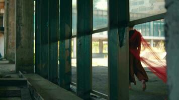 an Asian man walks in an abandoned building with a red cloth hanging down video