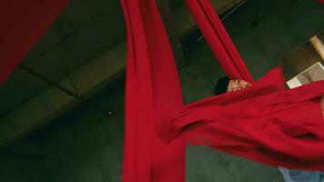 an Asian man dancing with a hanging red cloth very agile and energetic in an old building video