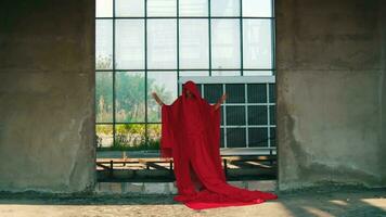 ein asiatisch Mann im ein rot Kleid ist Stehen im ein alt Gebäude mit Glas Fenster video