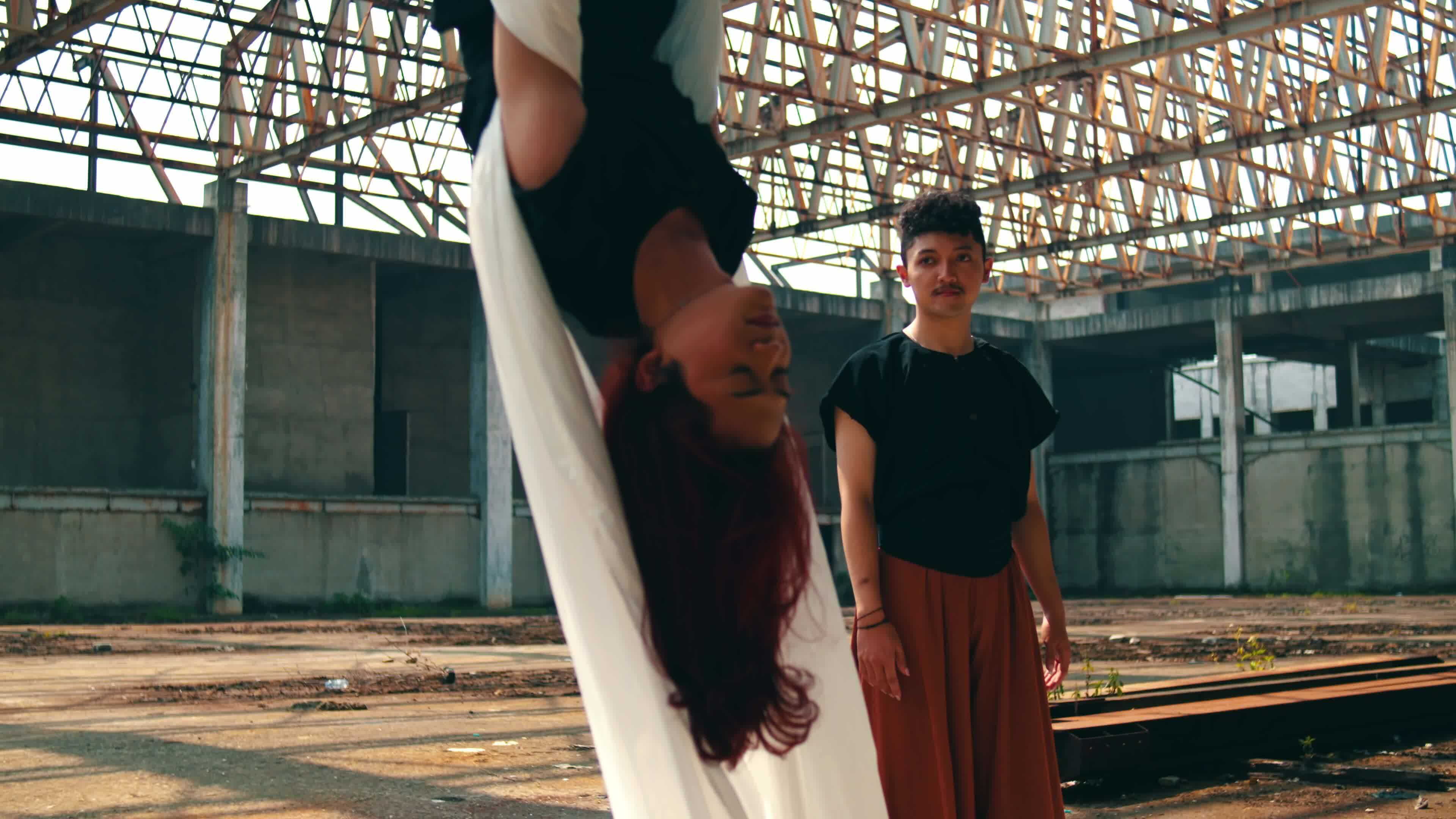 an Asian man approached and saw someone hanging with a white cloth