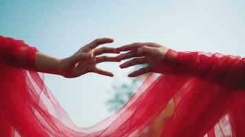 deux mains et les doigts avec rouge voile en essayant à toucher et tenir chaque autre contre le Contexte de le ciel video