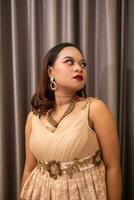 an Asian woman wearing a brown dress while attending a prom night at school photo