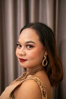 an Asian woman wearing a brown dress while attending a prom night at school photo