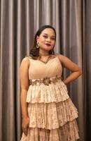 an Asian woman wearing a brown dress while attending a prom night at school photo